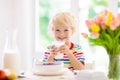 Child eating breakfast. Kid with milk and cereal Royalty Free Stock Photo