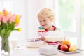 Child eating breakfast. Kid with milk and cereal Royalty Free Stock Photo