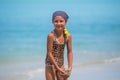 Child having fun at the beach, Cute girl playful in the sunny day, tropical beach.Playing with the sand and waves sea Royalty Free Stock Photo