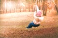 Child having  fun outdoors swinging on wooden homemade swing tied to a tree with a rope in spring or autumn Royalty Free Stock Photo