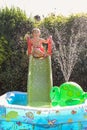 Child having fun playing in water in a garden paddling pool the boy is happy and smiling Royalty Free Stock Photo