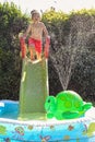 Child having fun playing in water in a garden paddling pool the boy is happy and smiling Royalty Free Stock Photo