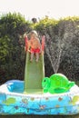 Child having fun playing in water in a garden paddling pool the boy is happy and smiling Royalty Free Stock Photo