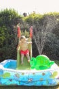 Child having fun playing in water in a garden paddling pool the boy is happy and smiling Royalty Free Stock Photo