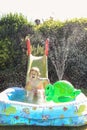 Child having fun playing in water in a garden paddling pool the boy is happy and smiling Royalty Free Stock Photo