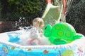 Child having fun playing in water in a garden paddling pool the boy is happy and smiling Royalty Free Stock Photo