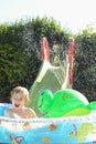 Child having fun playing in water in a garden paddling pool the boy is happy and smiling Royalty Free Stock Photo