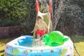 Child having fun playing in water in a garden paddling pool the boy is happy and smiling Royalty Free Stock Photo
