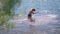 Happy guy is swimming in a mountain river. Water spray, hot summer day