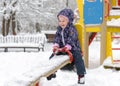 Child having fun on seesaw in winter