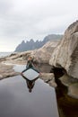 Child, having fun in Tungeneset, Senja, Norway, jumping over big puddle, making reflection in water