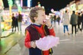 Child having a great time eating a candy floss at a night fair Royalty Free Stock Photo