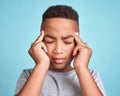 Child with headache, stress and mental health problem or fatigue pain on blue studio background. Frustrated african Royalty Free Stock Photo