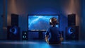 A child in headphones playing video game on the console.Little boy sitting in front of TV set screen in a dark room. Royalty Free Stock Photo