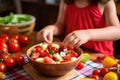 child helping to prepare watermelon feta salad