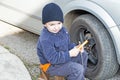 Child helps dismantle a car wheel