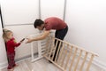 Child helps father to assemble cot, giving screwdriver to the father.