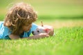 Child with her doggy lying on lawn. Close up, copy space. Kid plays with little dog chihuahua mixed doggy.