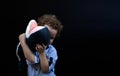 child hiding his face behind a stuffed animal