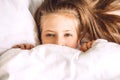 Child hiding under duvet in bed Royalty Free Stock Photo