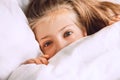 Child hiding under duvet in bed Royalty Free Stock Photo