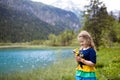 Child hiking in flower field at mountain lake Royalty Free Stock Photo