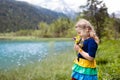 Child hiking in flower field at mountain lake Royalty Free Stock Photo