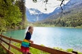 Child hiking in flower field at mountain lake Royalty Free Stock Photo