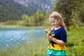 Child hiking in flower field at mountain lake Royalty Free Stock Photo