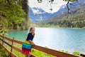 Child hiking in flower field at mountain lake Royalty Free Stock Photo