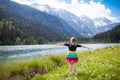 Child hiking in flower field at mountain lake Royalty Free Stock Photo