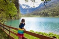 Child hiking in flower field at mountain lake Royalty Free Stock Photo