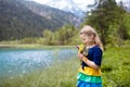 Child hiking in flower field at mountain lake Royalty Free Stock Photo