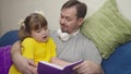 child with his father read an interesting book laugh, kid studies school homework remotely with dad, little girl laughs