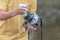 The child in his hands holds a digital SLR camera and washes it with a sponge