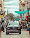 Child with his head out of the car on the street, India, vertical