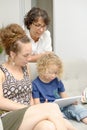 Child and his mother with grandmother play with tablet Royalty Free Stock Photo