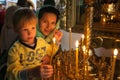 A child with his mother lighting a candle in a church.