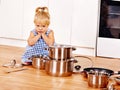 Child holdig pan at kitchen.