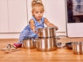 Child holdig pan at kitchen