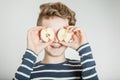Child holding apple halves in front of his eyes Royalty Free Stock Photo