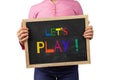 Child holding blackboard saying Let`s Play.