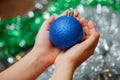 A child holding blue christmas ball