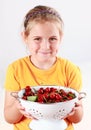 Child holding a bowl of fresh cherries