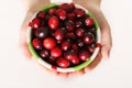 Child holding a bowl of fresh cranberries