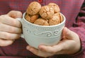 In the hands of the child Cup with Italian almond cookies Amaretti. Crispy Biscuits