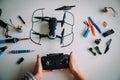 Child holding drone, kid making repair and maintenance, screws, screwdriver, tools on the table