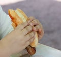 Child eating sausage in bread Royalty Free Stock Photo