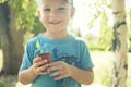 The child is holding a flower pot with a small plant Royalty Free Stock Photo