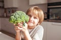 Child holding green broccoli.  Healthy  food concept. Child nutrition. Fresh vegetables in the hands of a cheerful boy child Royalty Free Stock Photo